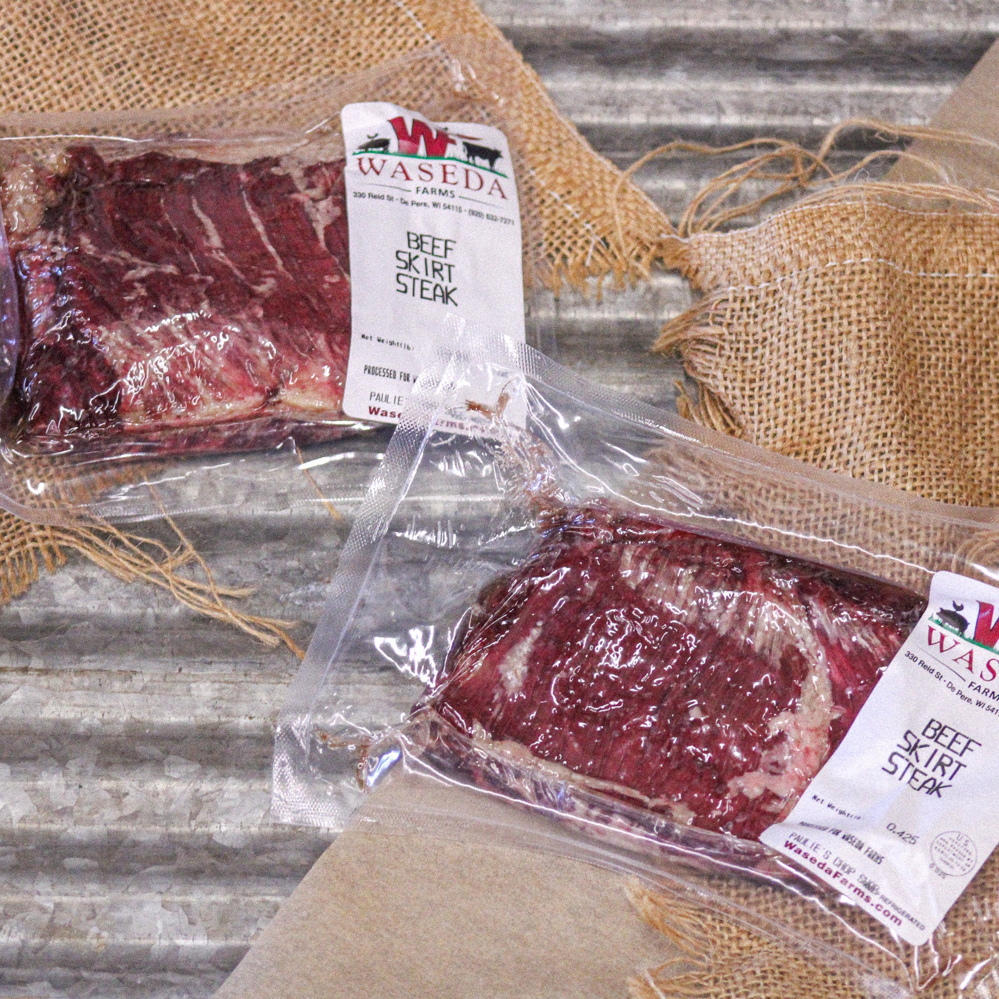 Waseda Farms grass fed skirt steak packages on rustic surface